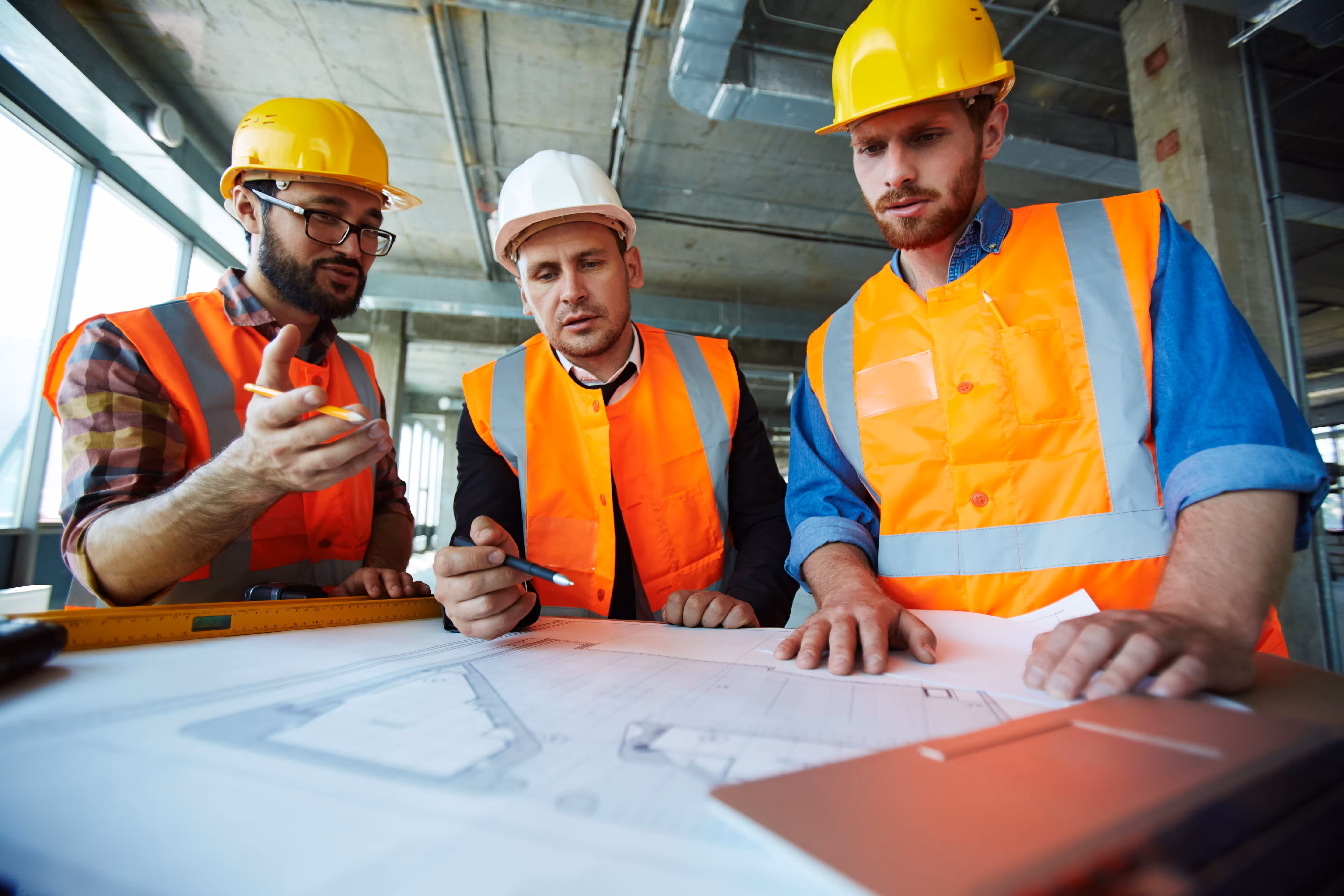 Team tecnico con planimetrie e operatori in cantiere DRD